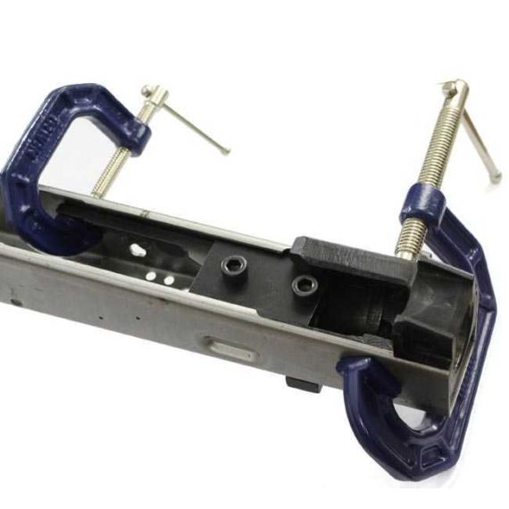 AK-Builder Rail Alignment Fixture, black steel, clamping lower rails in raw AK receiver, held by C-clamps.