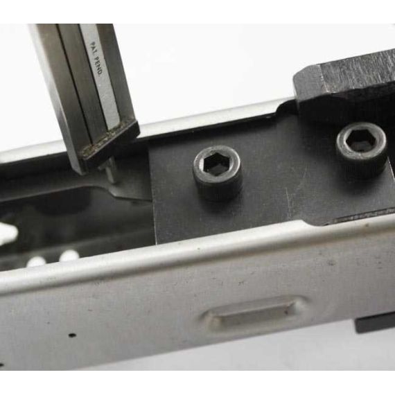 AK-Builder black oxide steel rail alignment fixture installed in unfinished stamped AK receiver, with leveling tool.