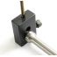 Close-up of AK-Builder black heat-treated steel gas piston drilling jig holding piston and TiN coated drill bit.